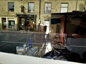 Bottles, beer mats and paperwork are piled up.